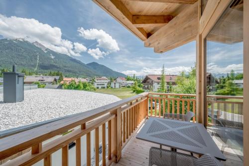 a patio with a table and chairs on a deck at AlpenParks Chalet & Apartment Alpina Seefeld in Seefeld in Tirol