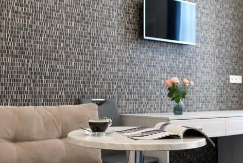 a living room with a table and a couch and a tv at Voyage in Odesa