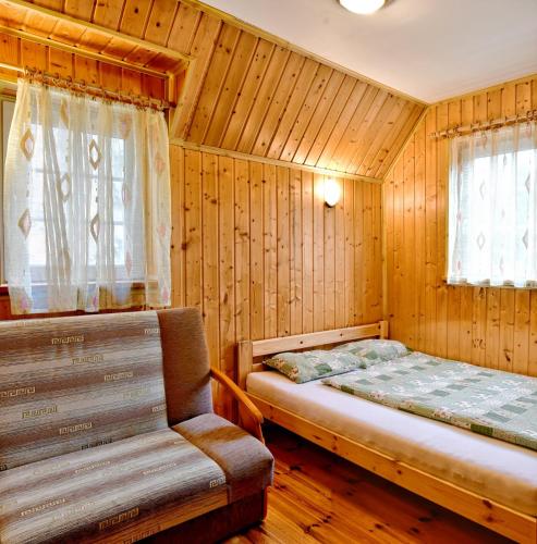 a bedroom with a bed and a bench in it at Janowa Chata in Kletno