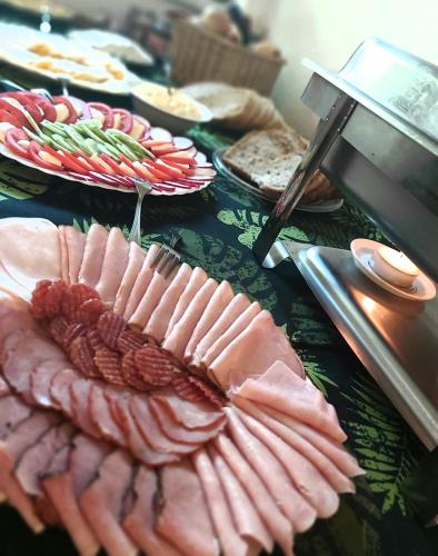 a table topped with plates of food with meat at NIECH TO SZLAK B&B in Wisła