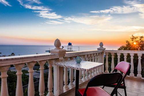 a table and chairs on a balcony with a view of the ocean at Dorvin Apartments in Dhërmi