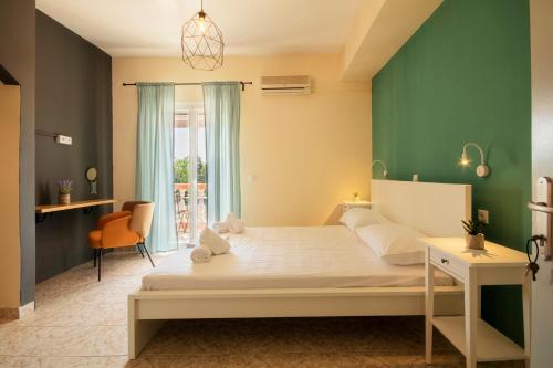 a bedroom with a large bed with a green wall at Issos Studios in Agios Georgios