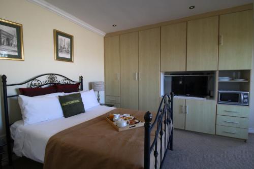 a bedroom with a bed with a television and a bed sidx sidx sidx at Port House in Bloubergstrand