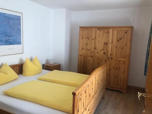 1 dormitorio con 2 camas y armario de madera en Ferienwohnungen Oberau, en Berchtesgaden