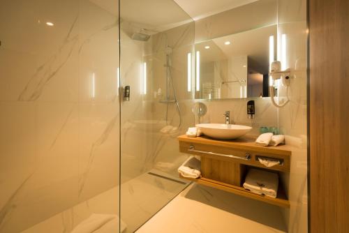 a bathroom with a tub and a shower stall at Hotel dasMEI in Innsbruck