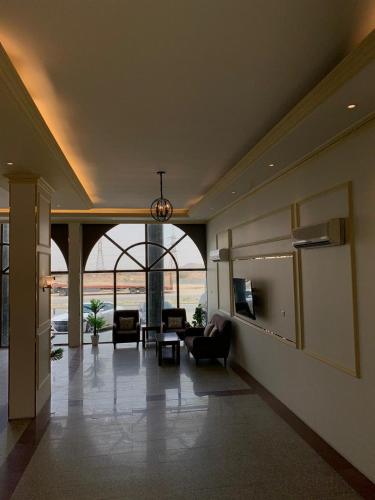 Al ḨawīyahにあるRadiha Hotel Suitesのリビングルーム(ソファ、椅子付)