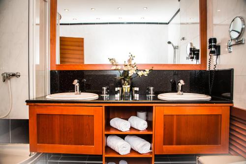 uma casa de banho com 2 lavatórios e um espelho grande em Hotel Corvinus Vienna - Newly Renovated em Viena