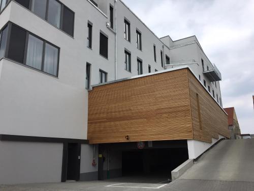a building with a wooden wall on the side of it at SleepySleepy Hotel Dillingen in Dillingen an der Donau