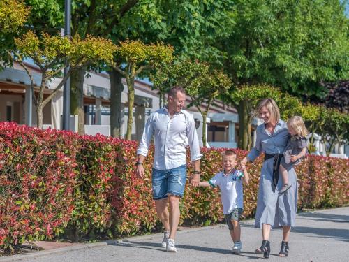 a man and a woman and a child walking down a street at Portofelice Camping Village in Eraclea Mare