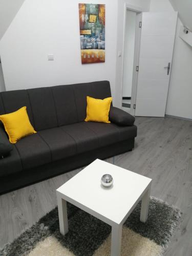 a living room with a black couch and a white coffee table at Apartman Romana Duplex Divčibare in Divčibare