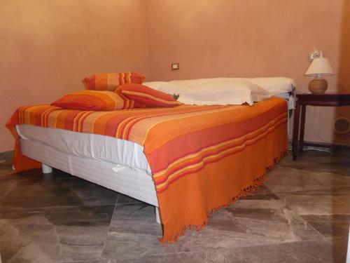 アゲにあるRifugio Storico sul Mareのベッド(オレンジ&白の毛布、枕付)