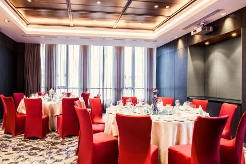 a conference room with tables and red chairs at Hotel Indigo Shanghai On The Bund by IHG in Shanghai