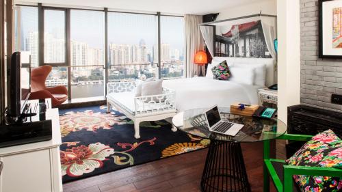 a hotel room with a bed and a glass table at Hotel Indigo Shanghai On The Bund by IHG in Shanghai