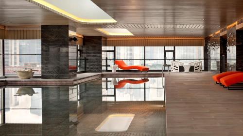 a lobby with a pool and orange furniture at Hotel Indigo Shanghai On The Bund by IHG in Shanghai