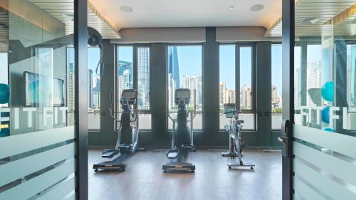 an office with treadmills and exercise machines in front of windows at Hotel Indigo Shanghai On The Bund by IHG in Shanghai