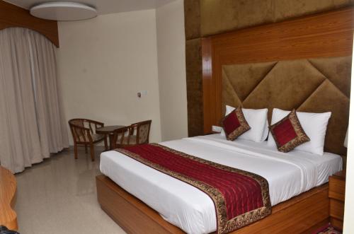 a bedroom with a large bed and a table at HOTEL ANAND INTERNATIONAL in Bodh Gaya