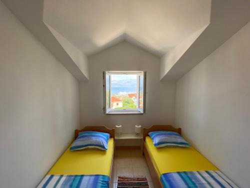 two beds in a small room with a window at The View in Supetar