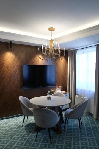 Un comedor con mesa y sillas y un televisor. en Hotel Jelena Brčko, en Brčko