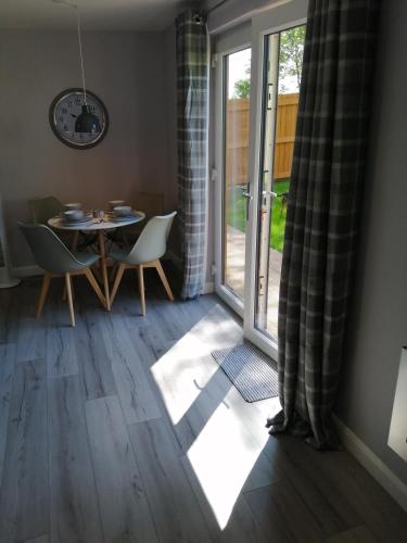 a room with a table and chairs and a sliding glass door at Lake District and Eden Valley Thornhill Lodge in Long Marton