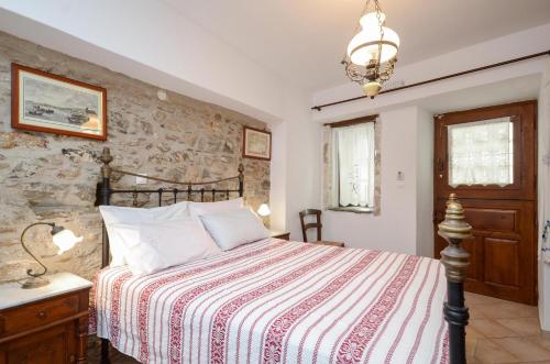 a bedroom with a bed and a stone wall at Venetiko Apartments in Naxos Chora