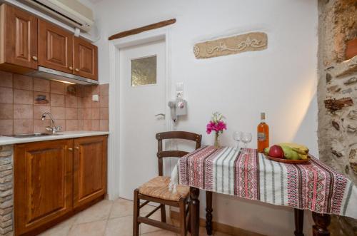 a kitchen with a table with a bowl of fruit on it at Venetiko Apartments in Naxos Chora