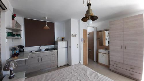 a kitchen with a white refrigerator and a sink at Haraki Beach in Haraki