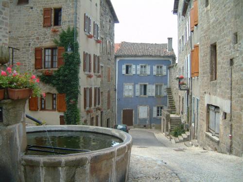 an alley with a fountain in the middle of a city at Le Ponant in Pradelles