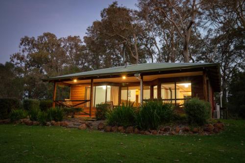 una pequeña casa con techo verde por la noche en Margaret River Chalets en Margaret River