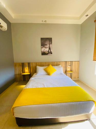 a bedroom with a large bed with a yellow blanket at Baden Hotel Suites in Amman