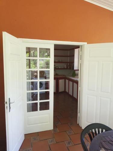 an open door to a room with a kitchen at Hotel La Chaumiere in Matoury