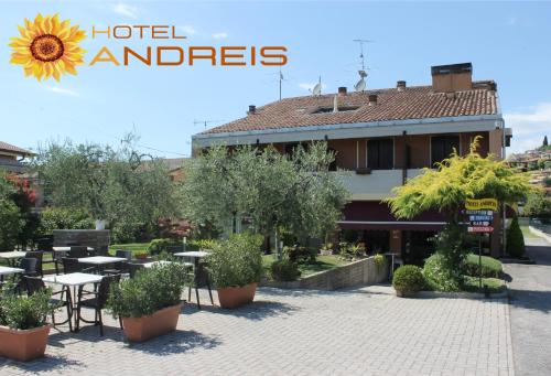 un hotel con tavoli e alberi e un edificio di Hotel Andreis a Cavaion Veronese
