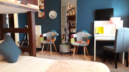 a bedroom with three chairs and a desk and a bed at Le Relais Des Chateaux Forts in Bitche