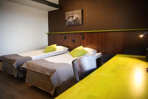 a hotel room with two beds and two lamps at Finlandia Hotel Airport Oulu in Kempele