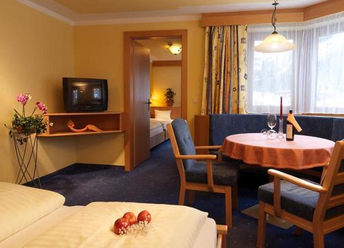 a hotel room with a bed and a table and a room at Hotel Gundolf in Sankt Leonhard im Pitztal