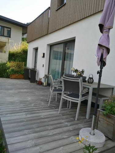 a patio with a table and chairs and an umbrella at Alpinlodge Ladis in Ladis