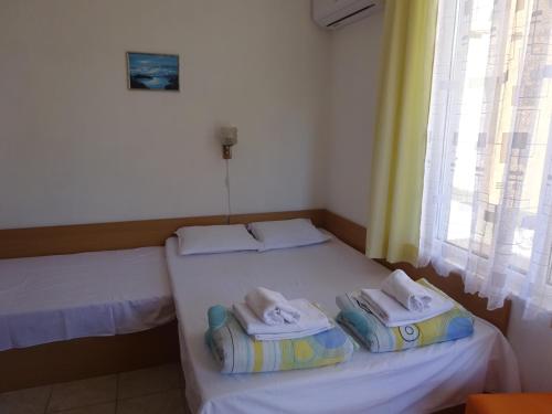 two beds in a small room with towels on them at Hris in Chernomorets