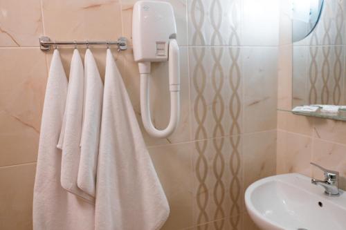 a bathroom with white towels and a sink at Hotel Halychyna in Ternopilʼ