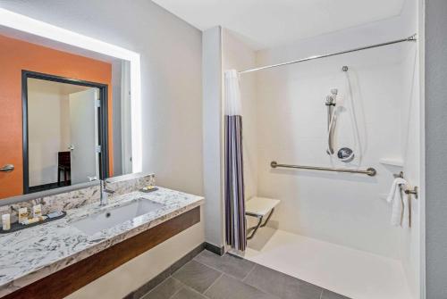 a bathroom with a tub and a sink and a shower at La Quinta by Wyndham Waco Baylor Downtown in Waco