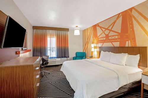 a hotel room with a bed and a desk at La Quinta by Wyndham Waco Baylor Downtown in Waco