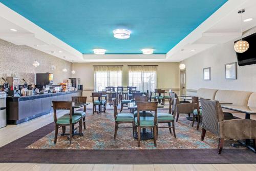 a restaurant with tables and chairs and a kitchen at La Quinta by Wyndham Corpus Christi Airport in Corpus Christi