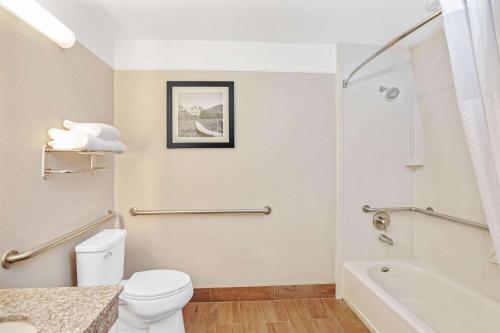 a bathroom with a white toilet and a bath tub at La Quinta by Wyndham Modesto Salida in Modesto