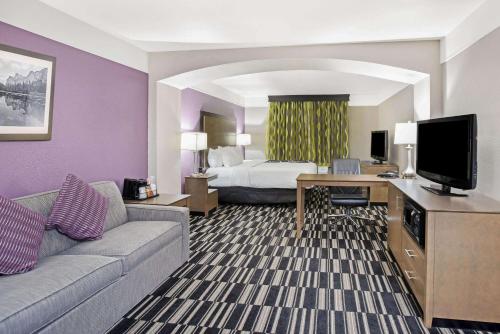 a hotel room with a bed and a couch and a television at La Quinta by Wyndham Modesto Salida in Modesto