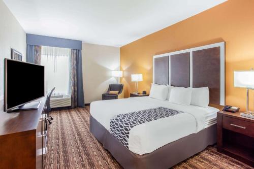 a hotel room with a bed and a flat screen tv at La Quinta by Wyndham Gonzales TX in Gonzales