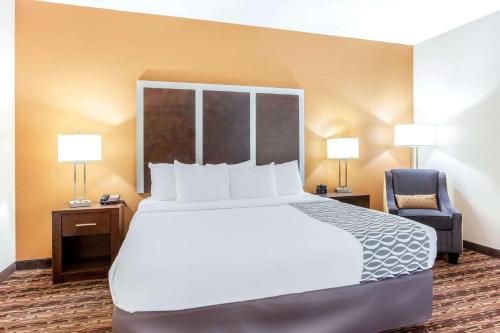 a hotel room with a large bed and a chair at La Quinta by Wyndham Gonzales TX in Gonzales