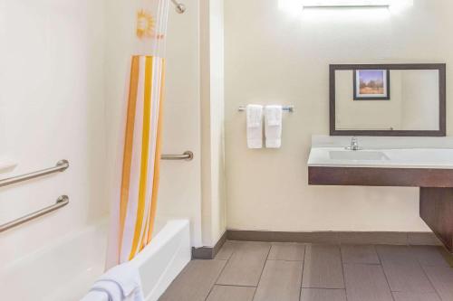 a bathroom with a sink and a tub and a toilet at La Quinta by Wyndham Luling in Luling
