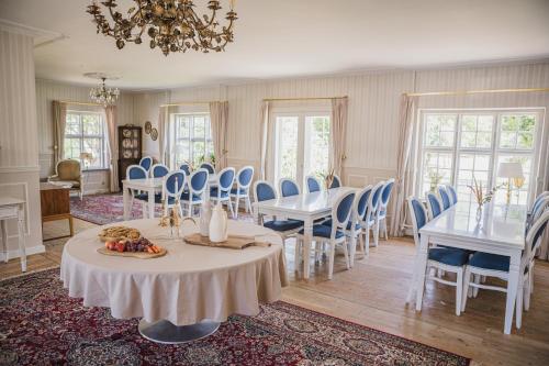 a dining room with tables and chairs and a chandelier at Sonnerupgaard Hotel & Konference in Kirke-Hvalsø