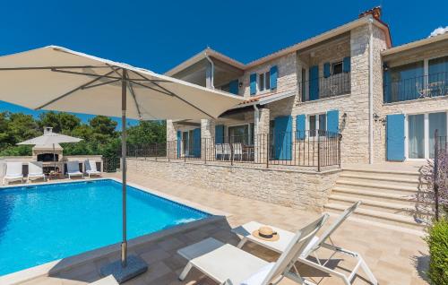 a villa with a swimming pool and an umbrella at Villa Sterpazzi - near Porec with Sea View, private Jacuzzi, Sauna and Pool in Višnjan
