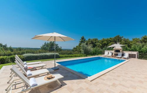 a swimming pool with chairs and an umbrella at Villa Sterpazzi - near Porec with Sea View, private Jacuzzi, Sauna and Pool in Višnjan