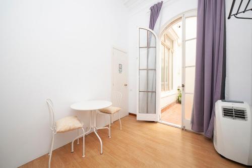 a room with a table and chairs and a window at Fabrizzios Terrace Hostel in Barcelona