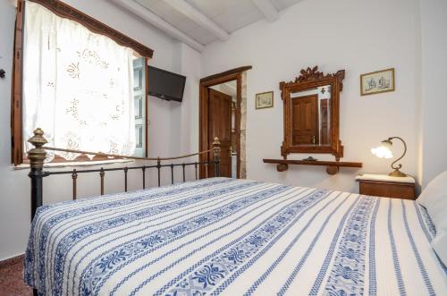 a bedroom with a bed with a blue and white blanket at Venetiko Apartments in Naxos Chora